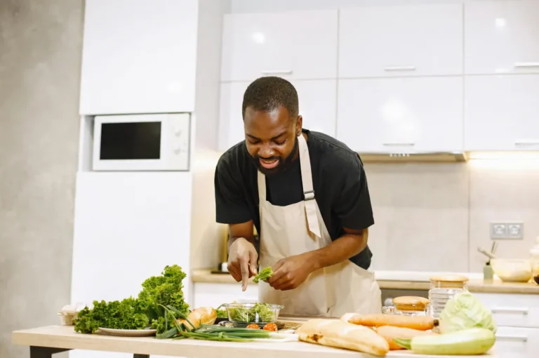 Chef preparing a fresh green salad in a modern kitchen.